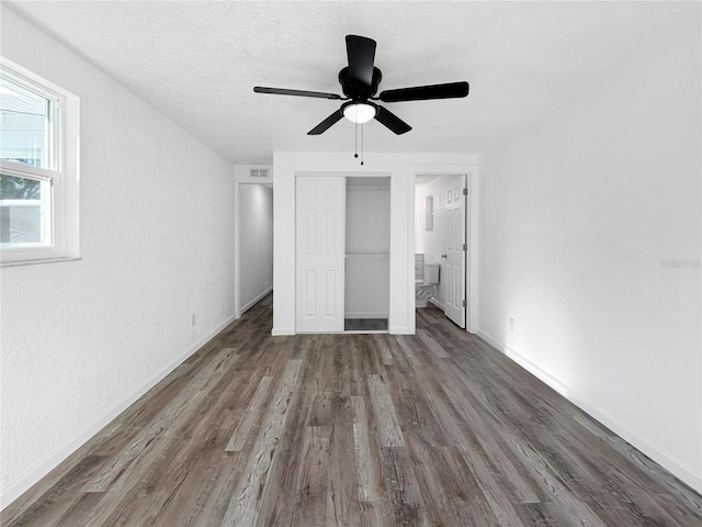 unfurnished bedroom with a ceiling fan, a textured ceiling, wood finished floors, a closet, and baseboards