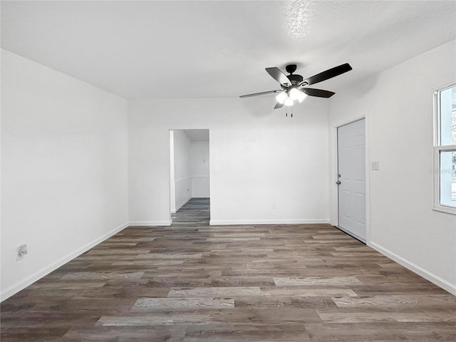 empty room with ceiling fan, baseboards, and wood finished floors