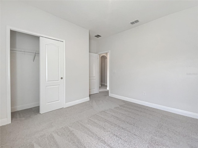 unfurnished bedroom featuring visible vents, baseboards, carpet, and a closet