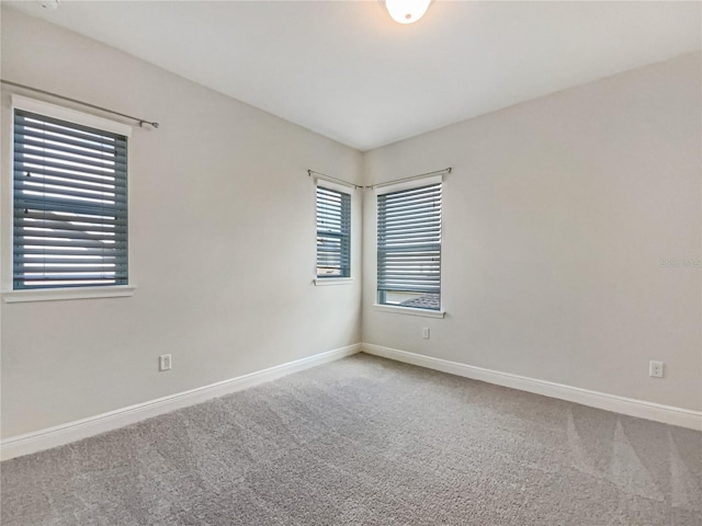 carpeted empty room with baseboards