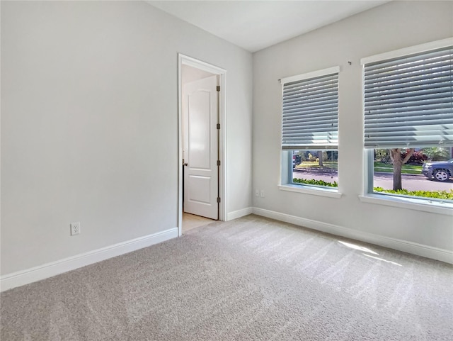 spare room featuring baseboards and carpet flooring