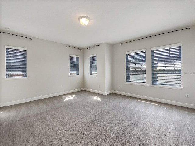 spare room featuring baseboards and carpet floors