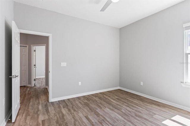 spare room with wood finished floors, baseboards, and ceiling fan