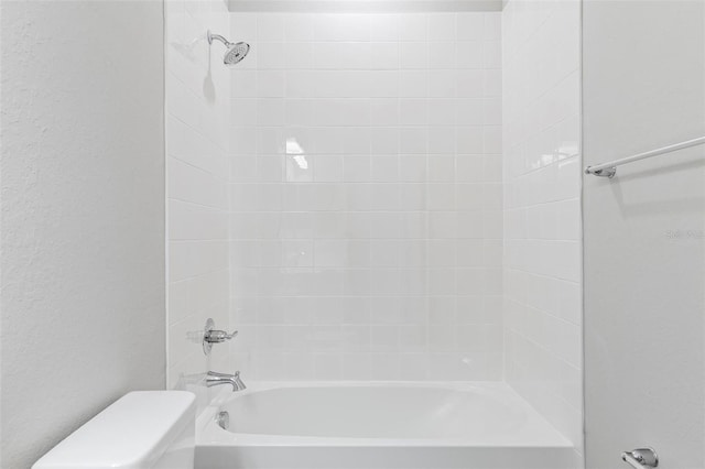 bathroom featuring shower / bathing tub combination and toilet