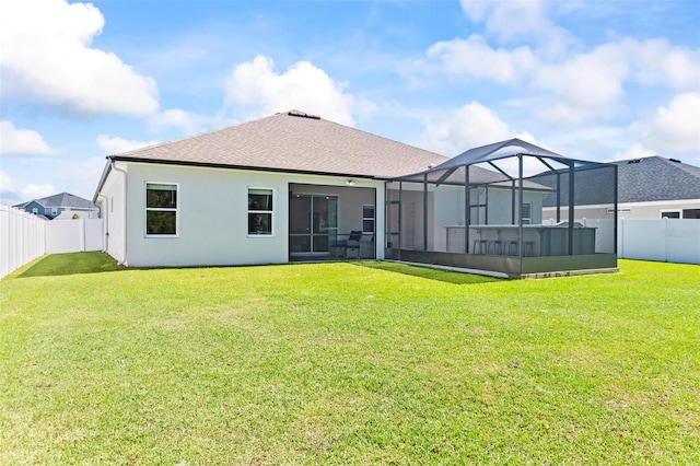 back of property featuring glass enclosure, a fenced backyard, a lawn, and stucco siding