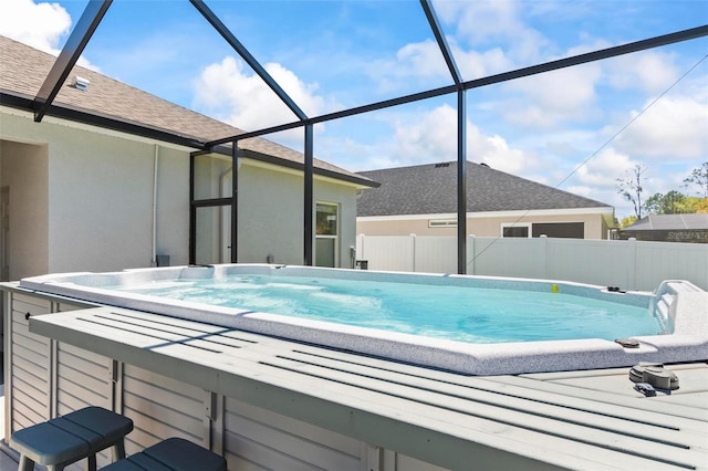 view of swimming pool featuring a jacuzzi, fence, glass enclosure, a fenced in pool, and a patio area