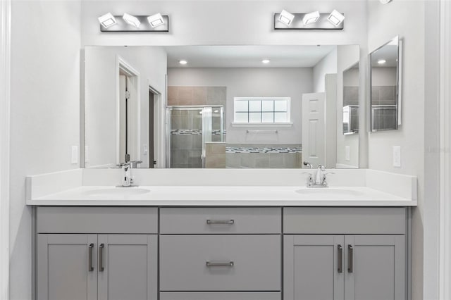 full bath featuring double vanity, a stall shower, and a sink