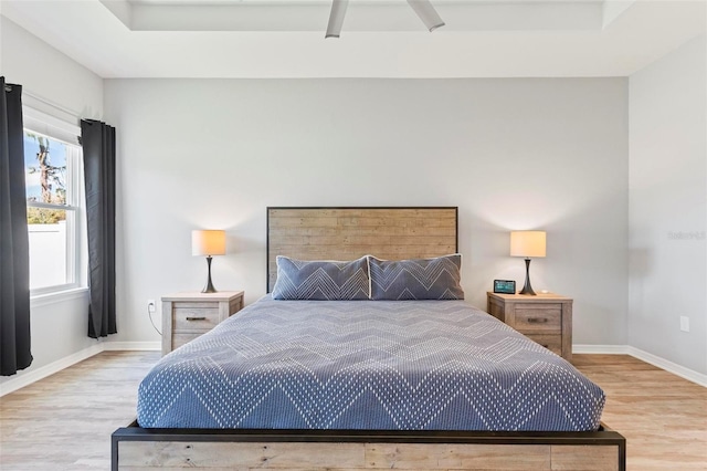 bedroom featuring ceiling fan, baseboards, and wood finished floors