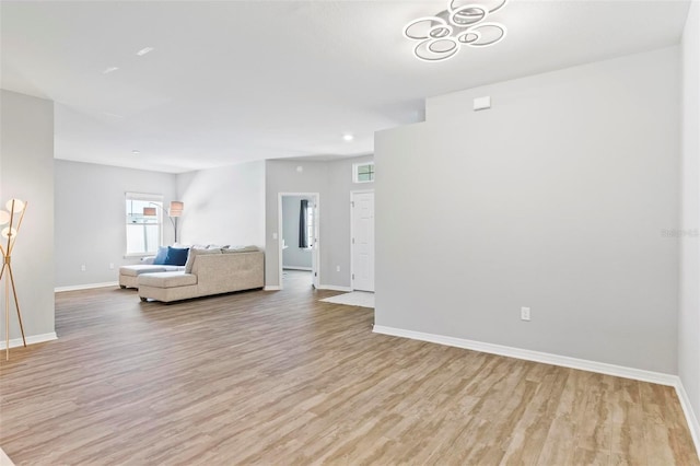 unfurnished living room with baseboards and light wood-style floors