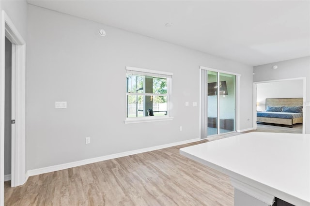 unfurnished bedroom with baseboards and light wood-type flooring