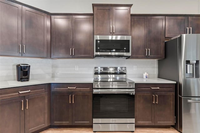 kitchen featuring light countertops, dark brown cabinets, backsplash, and stainless steel appliances