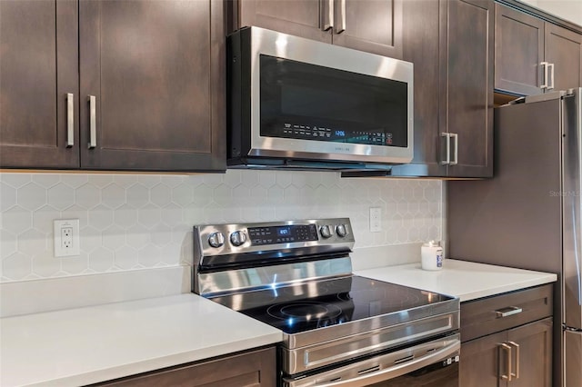 kitchen with dark brown cabinets, tasteful backsplash, appliances with stainless steel finishes, and light countertops