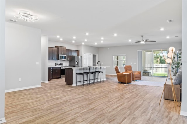 living area featuring recessed lighting, light wood-style floors, visible vents, and baseboards