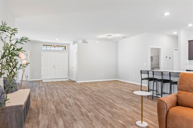 living area featuring light wood-style flooring, recessed lighting, and baseboards