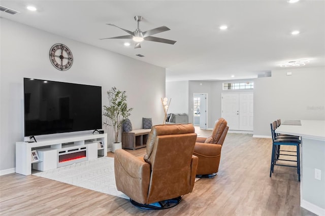 living area with light wood finished floors, visible vents, recessed lighting, and baseboards