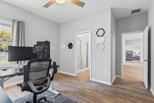 office area featuring visible vents, wood finished floors, baseboards, and ceiling fan