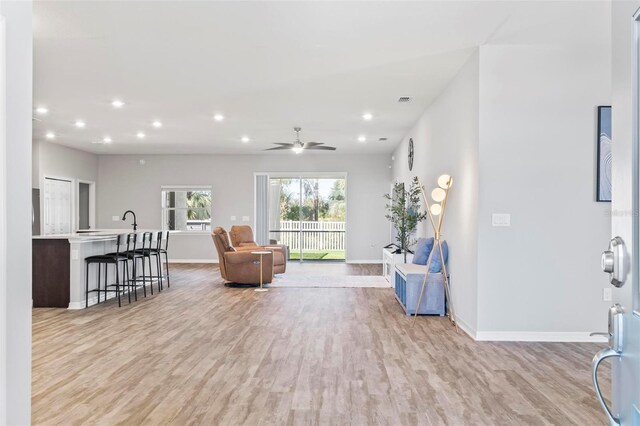 living area featuring recessed lighting, light wood-style floors, and baseboards