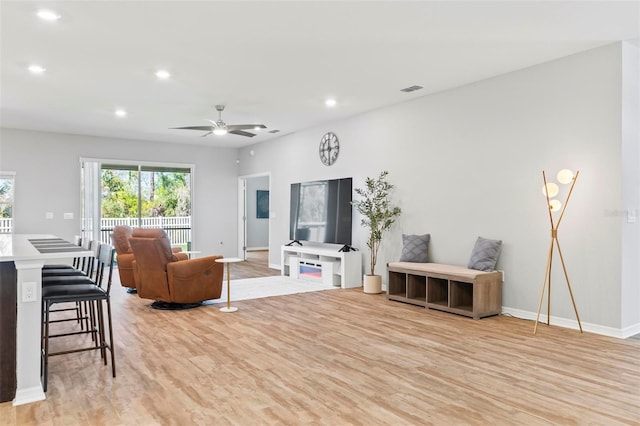 living area featuring recessed lighting, light wood-type flooring, and a ceiling fan