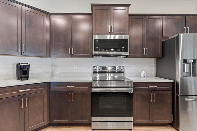149 St Thomas Dr, Mulberry, FL 33860 - kitchen with appliances with stainless steel finishes, decorative backsplash, light countertops, and dark brown cabinetry
