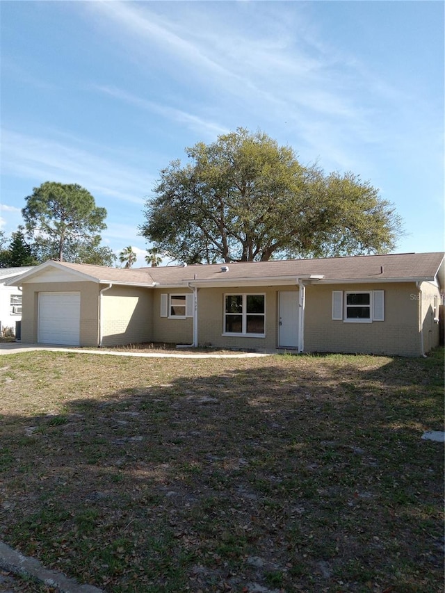 single story home with a garage, a front yard, and stucco siding