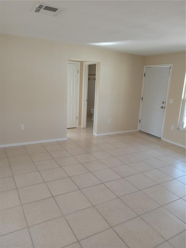 spare room featuring light tile patterned floors, baseboards, and visible vents