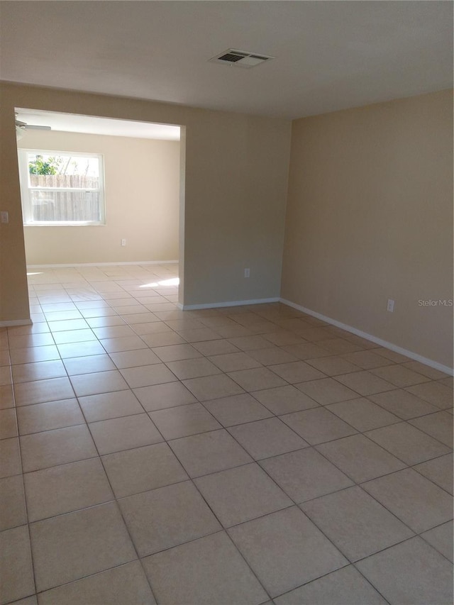 unfurnished room featuring light tile patterned floors, visible vents, and baseboards