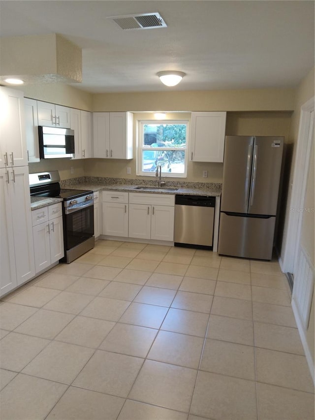 kitchen with a sink, stainless steel appliances, visible vents, and white cabinets