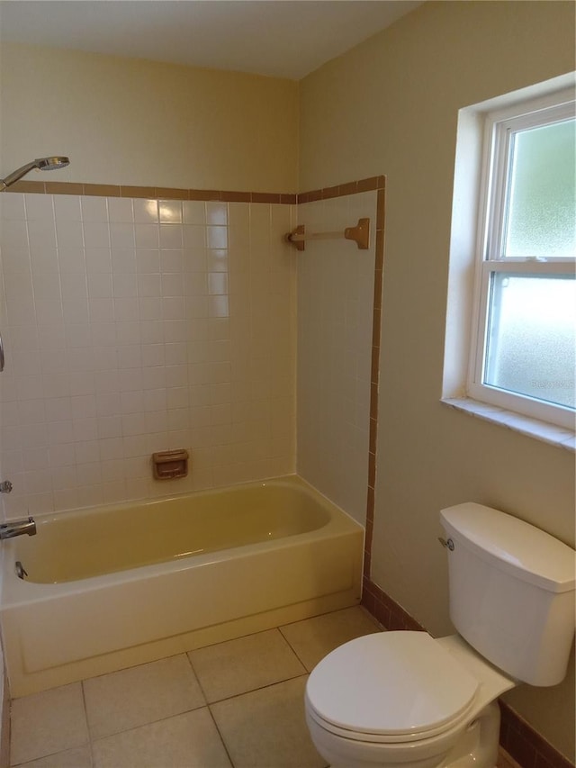 full bathroom with tile patterned flooring, tub / shower combination, toilet, and baseboards