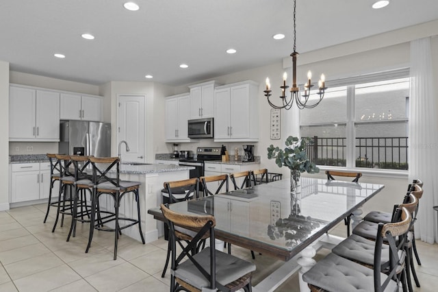 dining room with a notable chandelier, recessed lighting, and light tile patterned floors