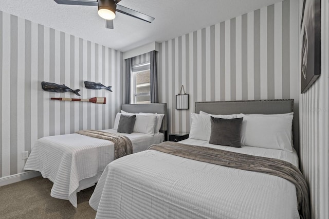 carpeted bedroom featuring wallpapered walls, ceiling fan, and a textured ceiling