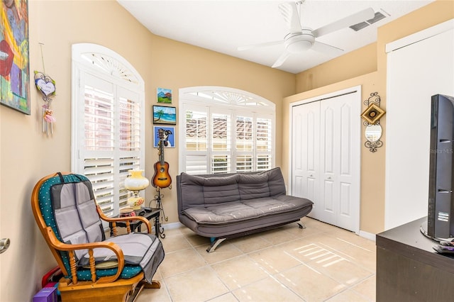 sitting room with light tile patterned flooring, baseboards, visible vents, and ceiling fan