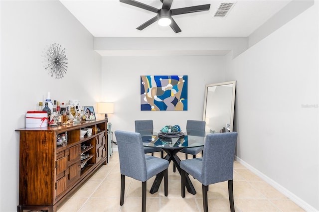 dining area featuring light tile patterned flooring, a ceiling fan, visible vents, and baseboards