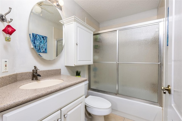 full bath featuring tile patterned flooring, toilet, vanity, combined bath / shower with glass door, and a textured ceiling