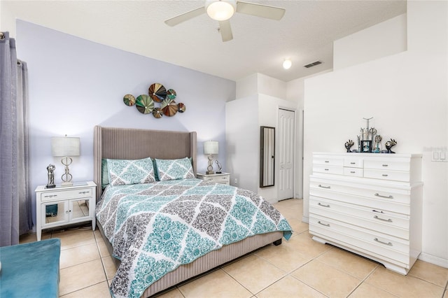 bedroom with light tile patterned floors, visible vents, a textured ceiling, and a ceiling fan