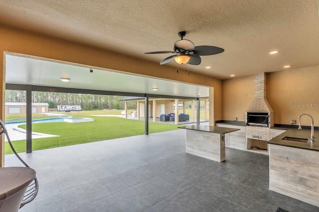 view of patio / terrace with a sink, a swimming pool, area for grilling, and ceiling fan