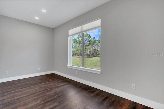 empty room with recessed lighting, dark wood-type flooring, and baseboards