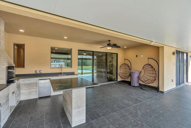 view of patio featuring a sink, an outdoor kitchen, and ceiling fan