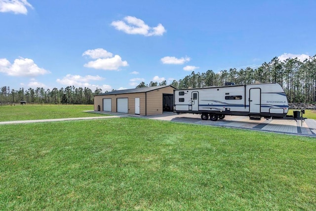 manufactured / mobile home with a detached garage, an outbuilding, and a front lawn