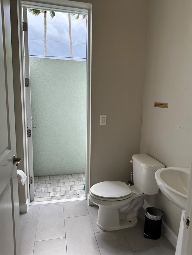 full bath featuring tile patterned flooring, a stall shower, and toilet