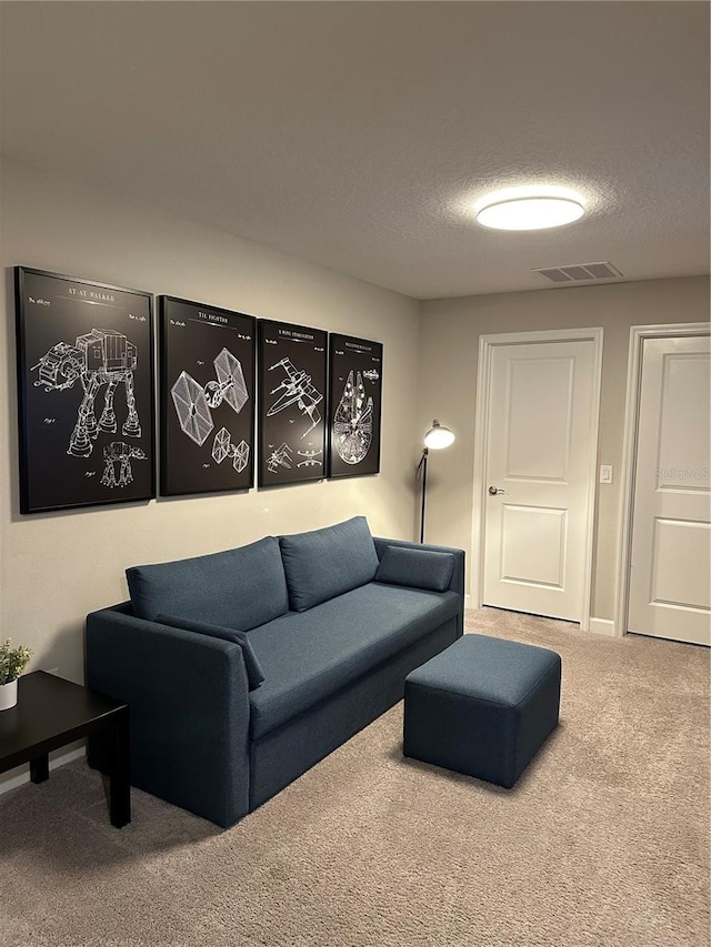 living room with carpet, visible vents, and a textured ceiling