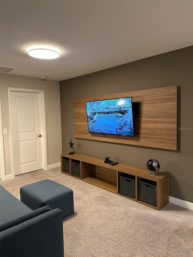 carpeted cinema with visible vents, a textured ceiling, and baseboards