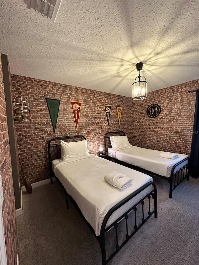 bedroom featuring carpet floors, a textured ceiling, and brick wall