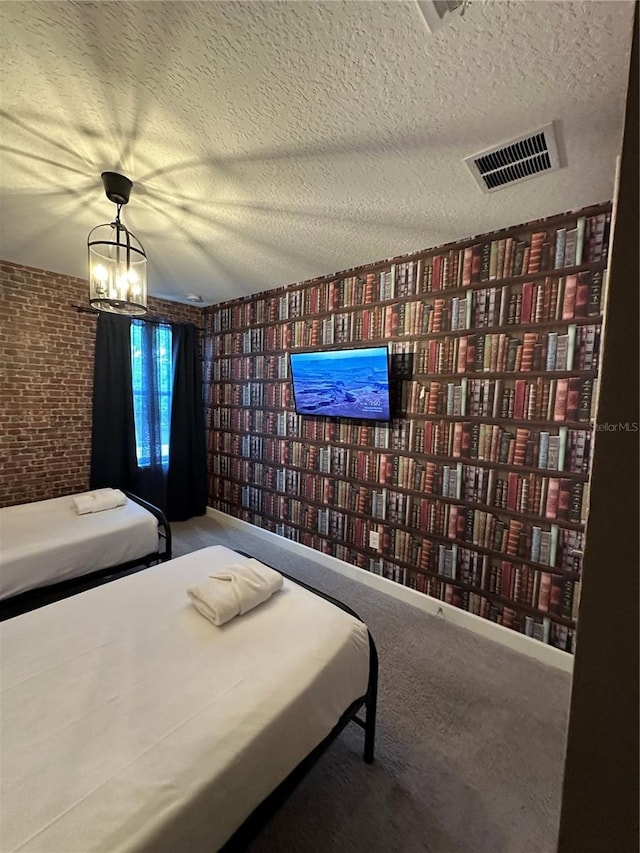 bedroom featuring visible vents, a textured ceiling, carpet floors, brick wall, and baseboards