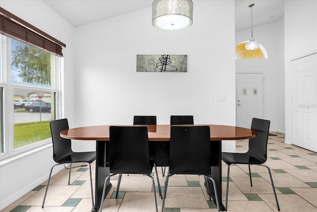 dining area featuring lofted ceiling, light tile patterned floors, and baseboards