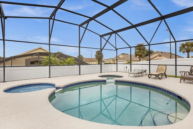 view of swimming pool with glass enclosure, a patio, and a pool with connected hot tub