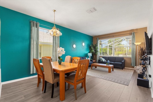 229 Troon Cir, Davenport, FL 33897 - dining room featuring an accent wall, wood finished floors, and plenty of natural light