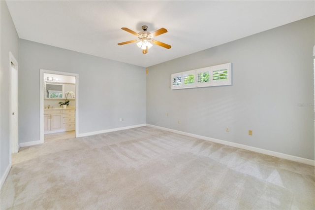 empty room with light colored carpet, baseboards, and ceiling fan