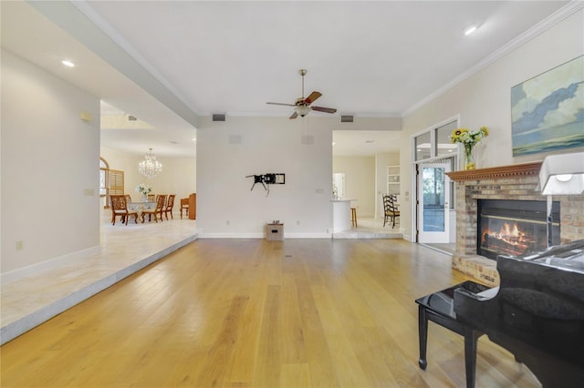 living room featuring visible vents, wood-type flooring, crown molding, baseboards, and a brick fireplace