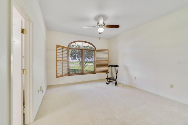 interior space with a ceiling fan, carpet, and baseboards