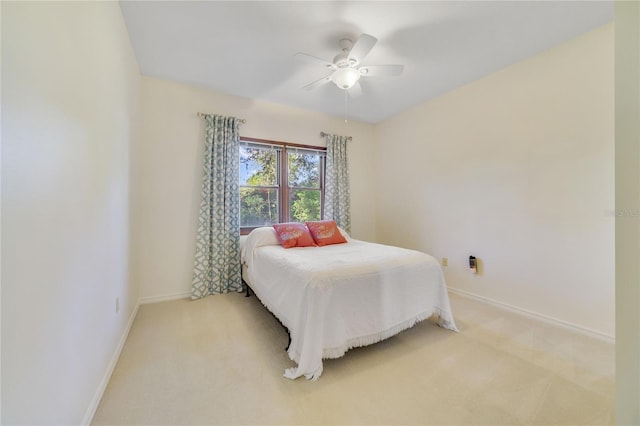 bedroom featuring light colored carpet, baseboards, and ceiling fan